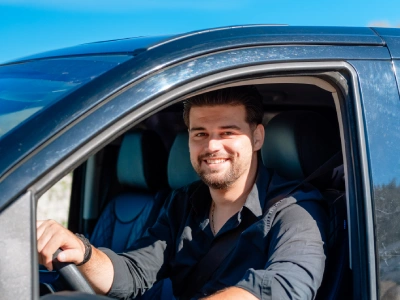 guy in black car driving and smiling