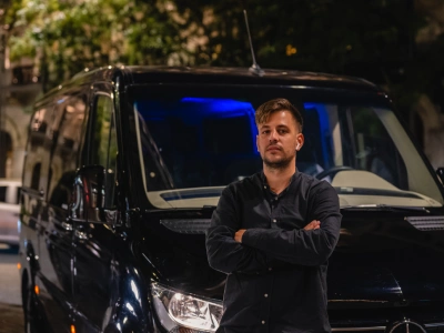 male driver in front of black mercedes jeep waiting