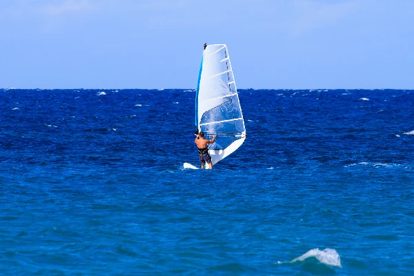 A man wind surfing on blue waters