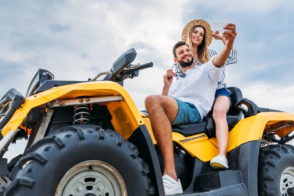 Couple taking selfies on a yellow ATV